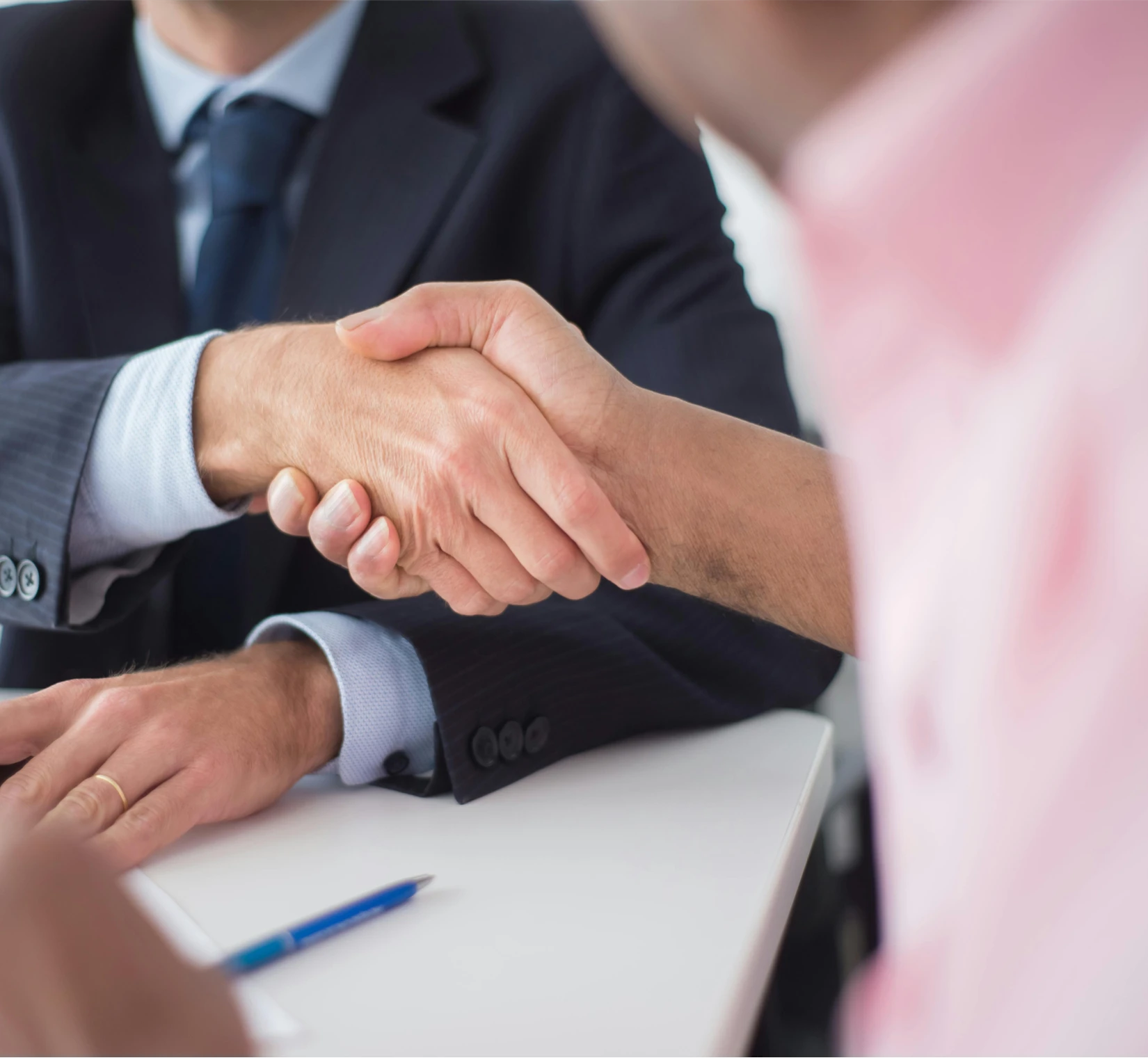 Two people shaking hands across a table